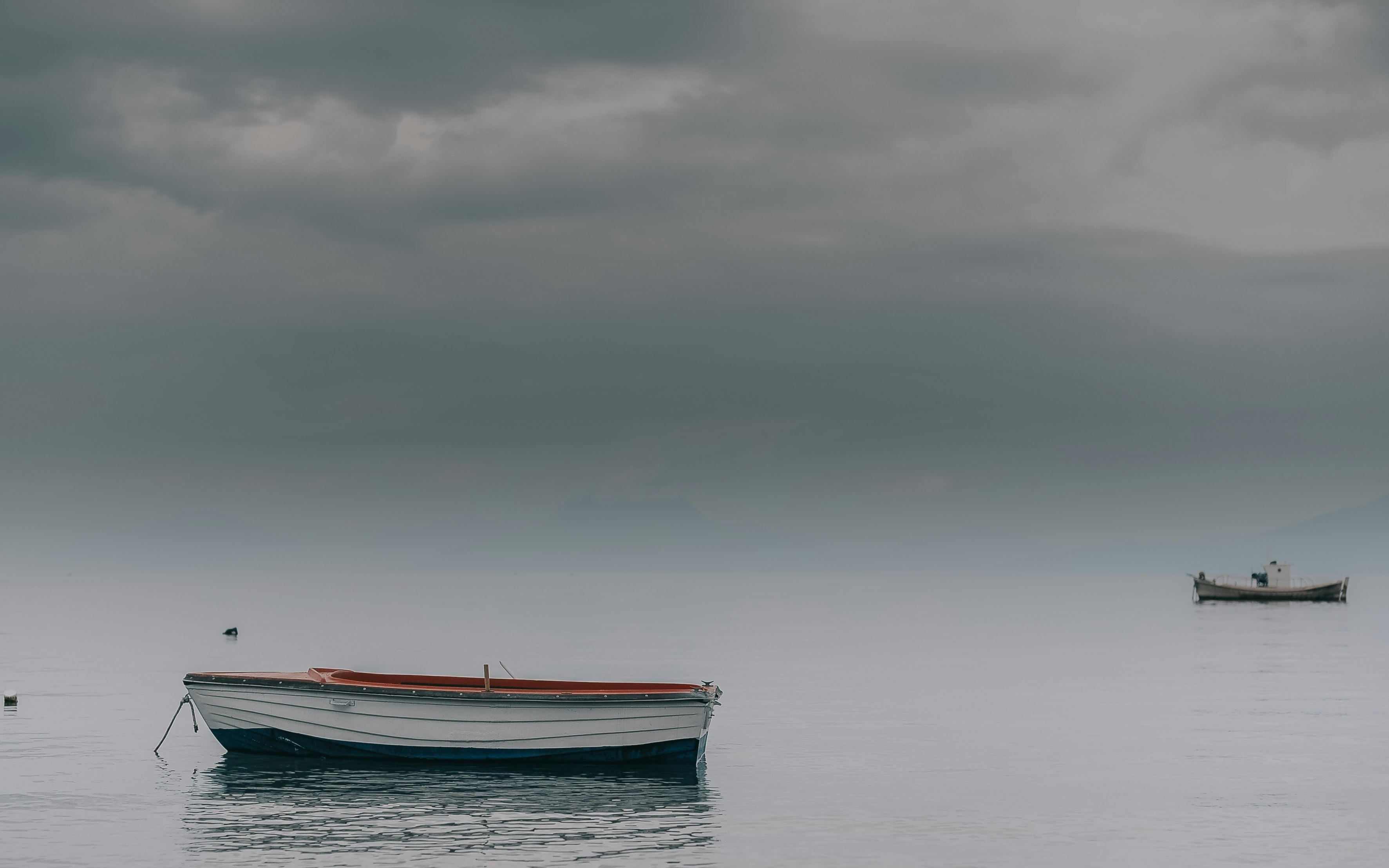 white canoe on calm sea at daytime